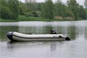 picture of black newfoundland dog swimming round boat