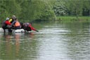 picture of owner sending black newfoundland dog from boat